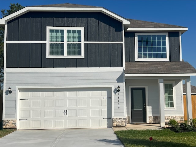 16457 Blossom Grove Dr, Conroe, TX 77303 - view of front of home with stone siding, an attached garage, concrete driveway, and roof with shingles