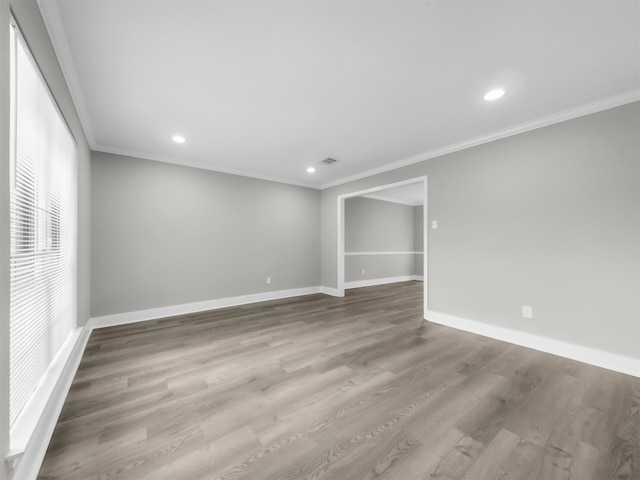 spare room with ornamental molding, baseboards, wood finished floors, and recessed lighting