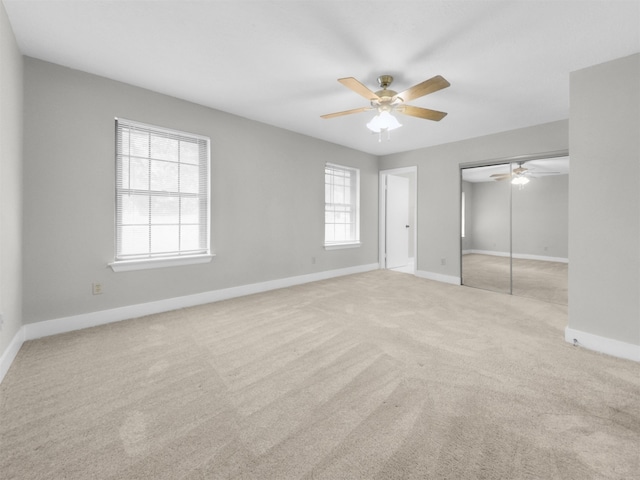 unfurnished bedroom featuring carpet flooring, baseboards, a closet, and a ceiling fan