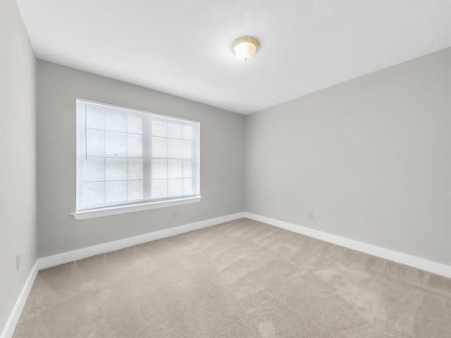 empty room with carpet floors and baseboards