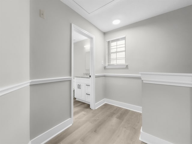 hallway featuring light wood-type flooring and baseboards