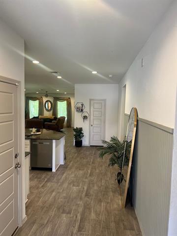 kitchen featuring dishwasher, dark countertops, and wood finished floors