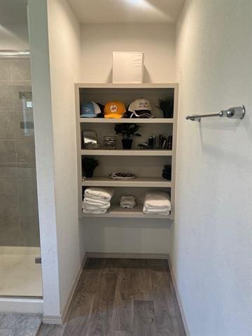 walk in closet with wood finished floors