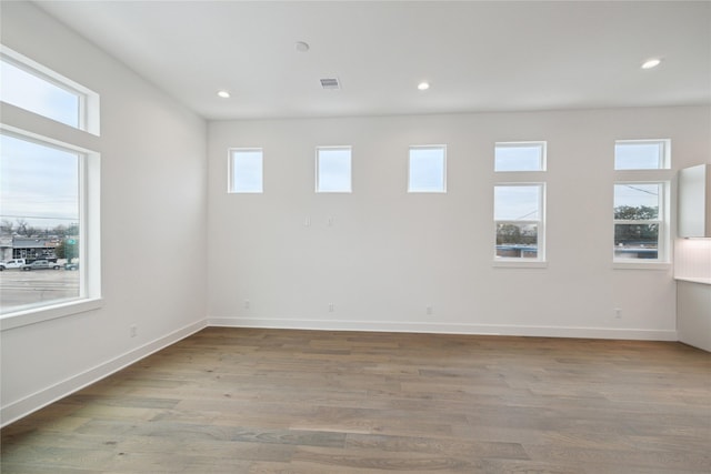 empty room with wood finished floors, recessed lighting, and baseboards