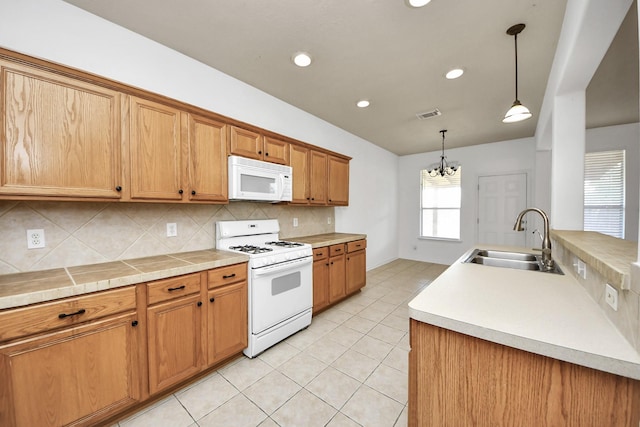 13114 Oak Ledge Dr, Houston, TX 77065 - kitchen with white appliances, a sink, tasteful backsplash, a chandelier, and light tile patterned floors