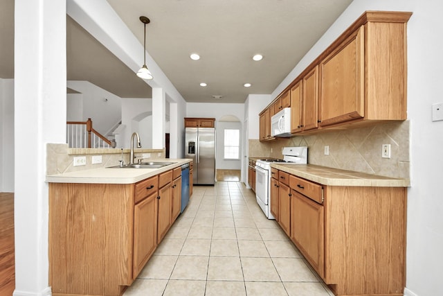 13114 Oak Ledge Dr, Houston, TX 77065 - kitchen featuring appliances with stainless steel finishes, a sink, backsplash, light countertops, and arched walkways