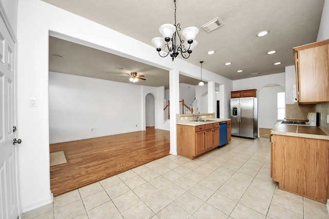 13114 Oak Ledge Dr, Houston, TX 77065 - kitchen featuring stainless steel refrigerator with ice dispenser, arched walkways, dishwashing machine, open floor plan, and range