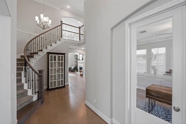 entrance foyer with a chandelier, stairway, wood finished floors, baseboards, and recessed lighting