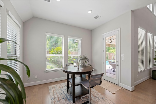 dining space featuring light wood finished floors, baseboards, vaulted ceiling, and recessed lighting