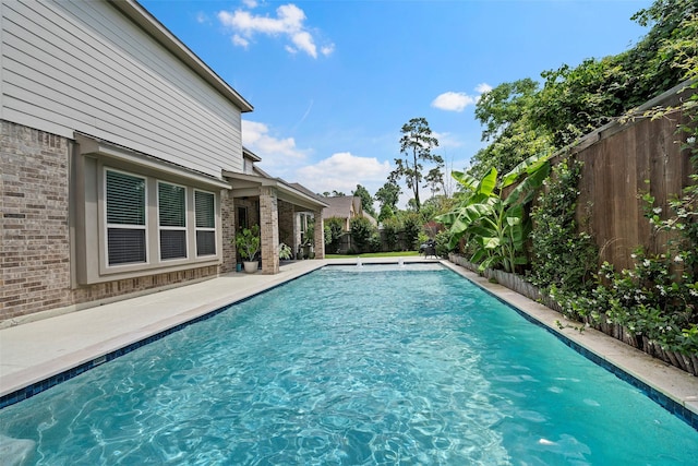 view of swimming pool featuring a fenced backyard and a patio