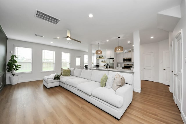 2003 Ballesteros St, Crosby, TX 77532 - living room featuring plenty of natural light, ceiling fan, light wood-type flooring, recessed lighting, and baseboards