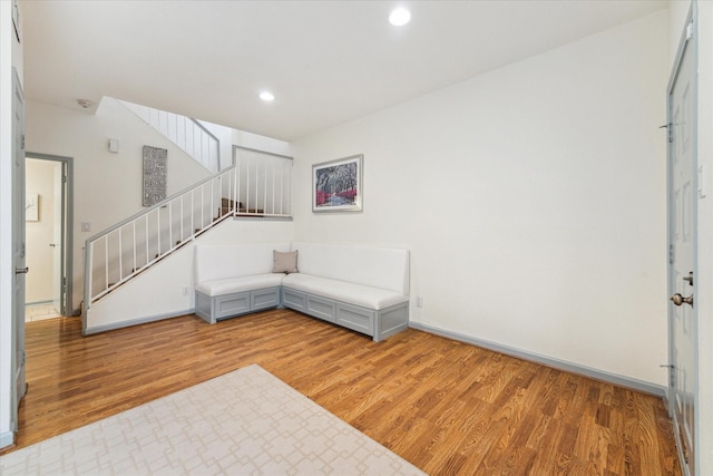 unfurnished living room featuring stairway, light wood-style floors, baseboards, and recessed lighting