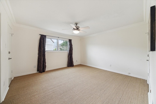 carpeted empty room featuring a ceiling fan, crown molding, and baseboards
