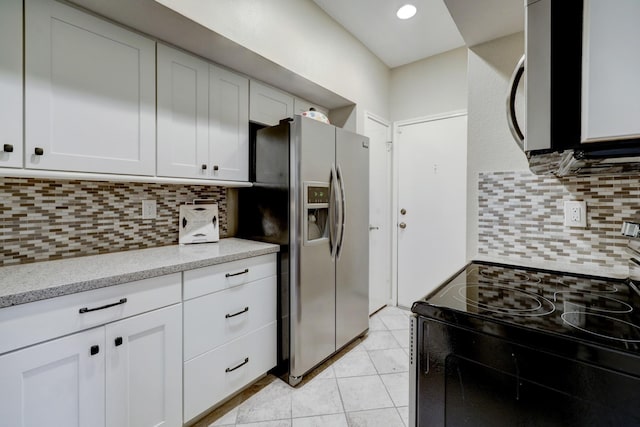 kitchen featuring black range with electric cooktop, stainless steel refrigerator with ice dispenser, white cabinetry, and tasteful backsplash
