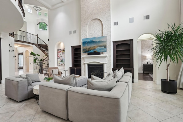 3109 Mcculloch Cir, Houston, TX 77056 - living area with a towering ceiling, light tile patterned flooring, arched walkways, and a fireplace