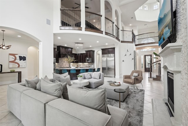 3109 Mcculloch Cir, Houston, TX 77056 - living room with a high ceiling, light tile patterned flooring, a large fireplace, a ceiling fan, and arched walkways