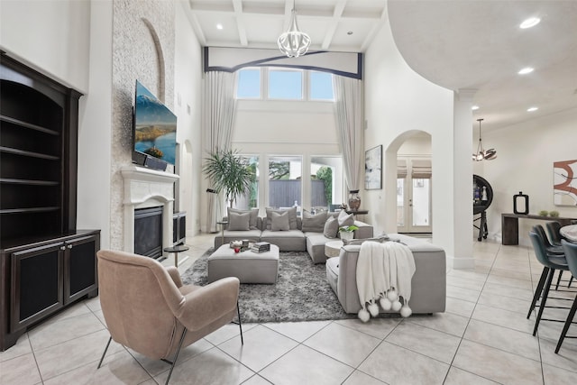 3109 Mcculloch Cir, Houston, TX 77056 - living area featuring a chandelier, a high ceiling, arched walkways, a glass covered fireplace, and light tile patterned flooring
