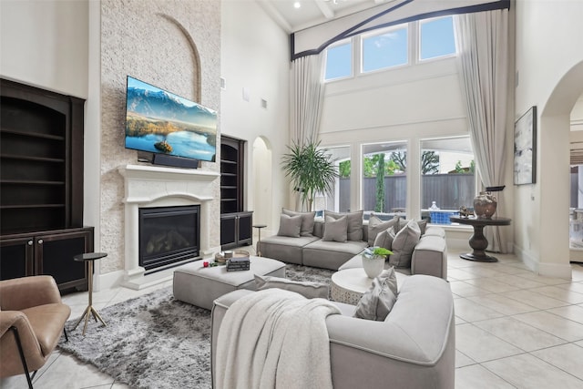 3109 Mcculloch Cir, Houston, TX 77056 - living area featuring arched walkways, a towering ceiling, tile patterned flooring, a glass covered fireplace, and built in shelves