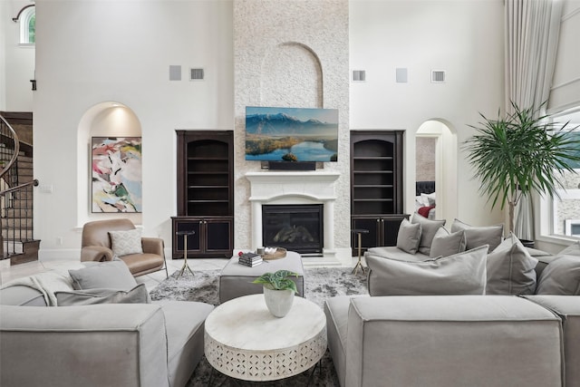3109 Mcculloch Cir, Houston, TX 77056 - living area featuring a high ceiling, built in shelves, stairway, a glass covered fireplace, and baseboards