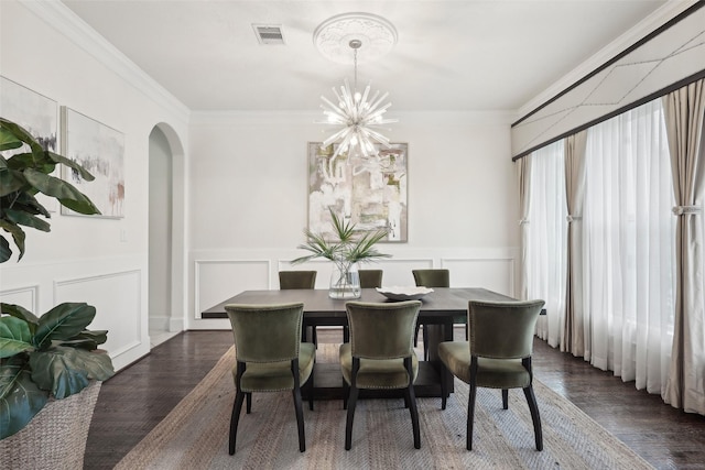 3109 Mcculloch Cir, Houston, TX 77056 - dining area featuring arched walkways, a chandelier, dark wood-type flooring, crown molding, and a decorative wall