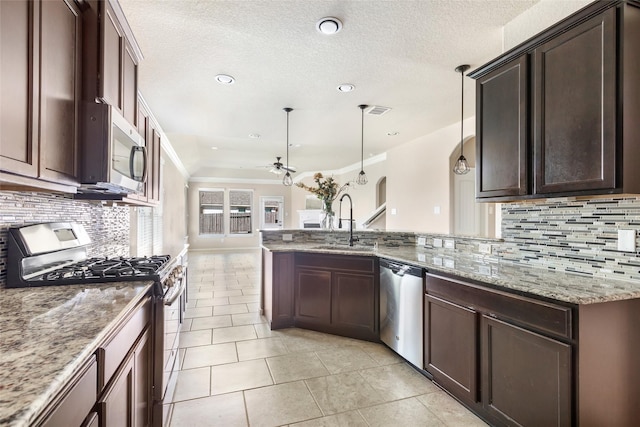 kitchen featuring appliances with stainless steel finishes, a sink, ceiling fan, light tile patterned floors, and decorative backsplash