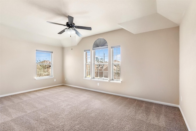 carpeted empty room with a ceiling fan, plenty of natural light, baseboards, and lofted ceiling
