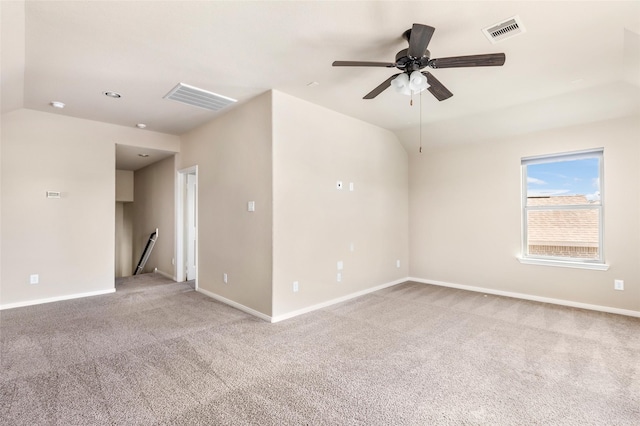 spare room featuring light colored carpet, a ceiling fan, baseboards, and vaulted ceiling