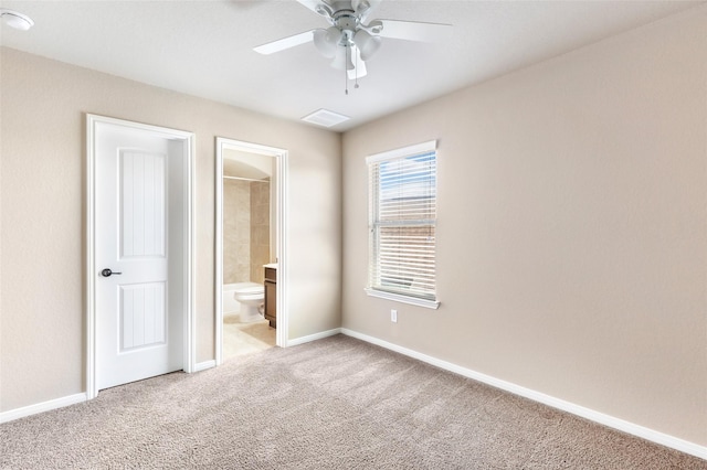 unfurnished bedroom featuring carpet, ensuite bathroom, baseboards, and a ceiling fan