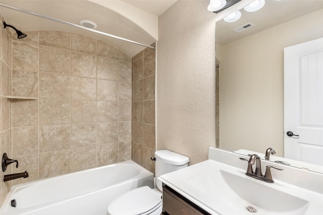 bathroom featuring a textured wall, bathtub / shower combination, toilet, and vanity
