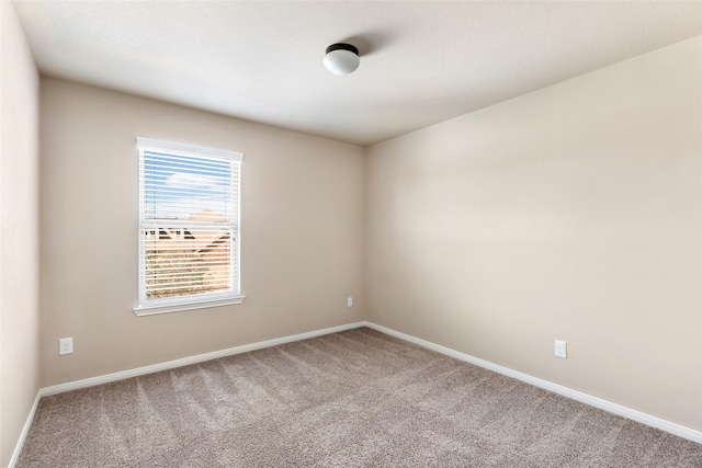 carpeted empty room with baseboards