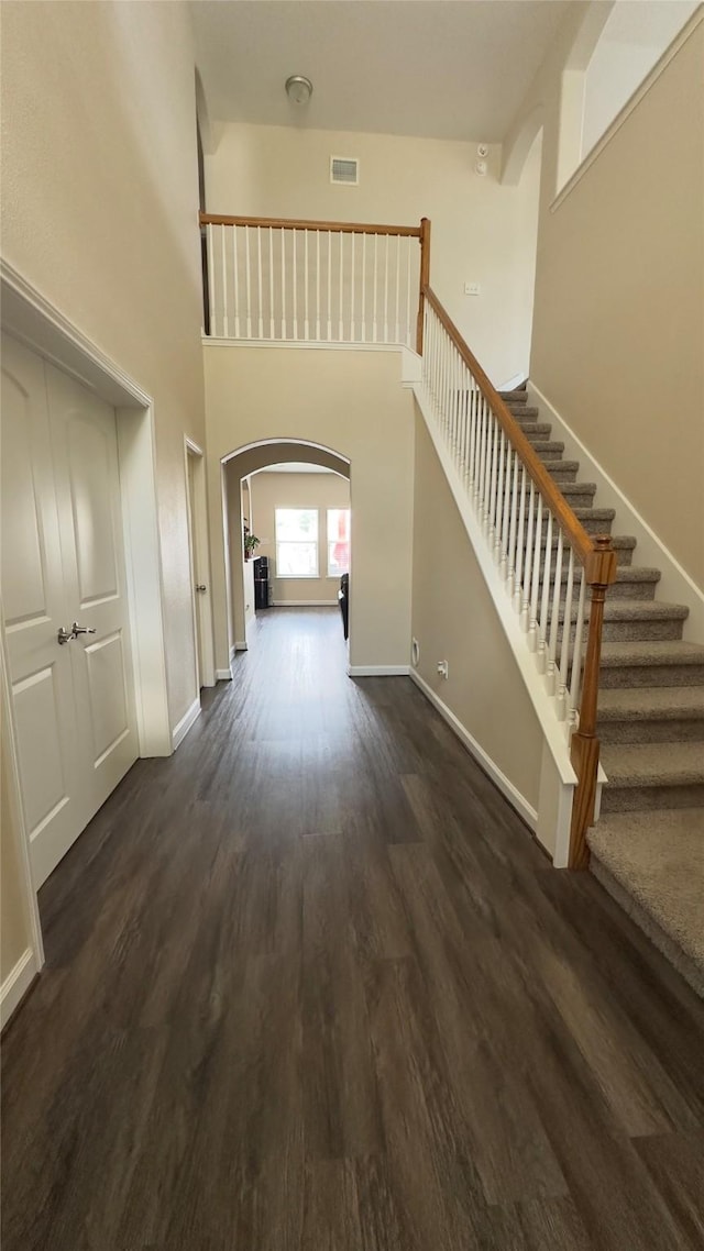 6514 Evening Rose Ln, Katy, TX 77449 - foyer entrance featuring arched walkways, dark wood-style flooring, baseboards, stairs, and a high ceiling