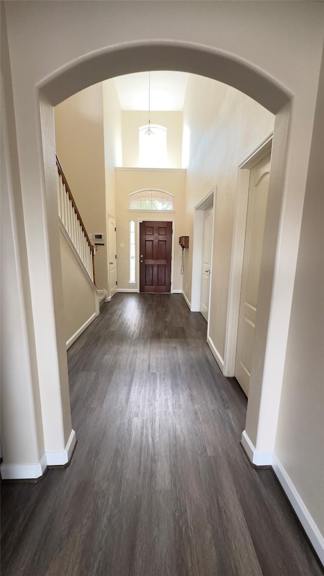 6514 Evening Rose Ln, Katy, TX 77449 - foyer entrance featuring dark wood finished floors, baseboards, a high ceiling, stairway, and arched walkways