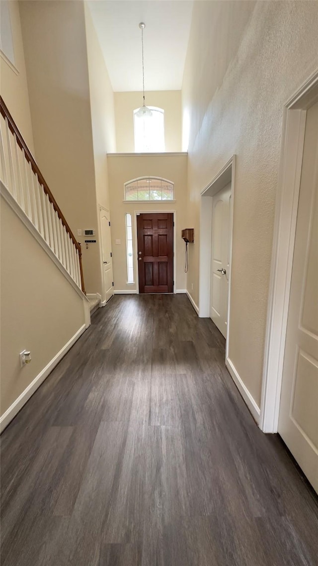 6514 Evening Rose Ln, Katy, TX 77449 - entrance foyer featuring dark wood-type flooring, a towering ceiling, stairs, and baseboards