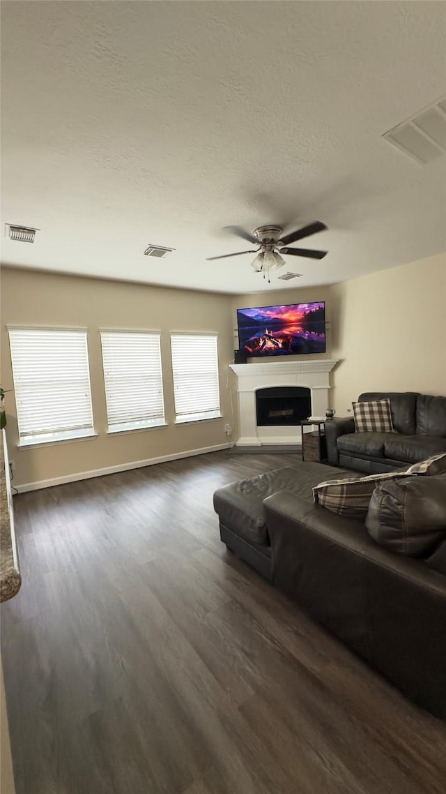 6514 Evening Rose Ln, Katy, TX 77449 - living area with wood finished floors, a fireplace, a textured ceiling, a ceiling fan, and baseboards