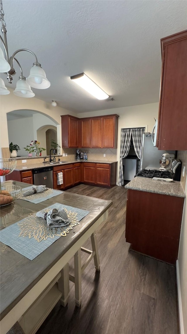 6514 Evening Rose Ln, Katy, TX 77449 - kitchen featuring dishwasher, arched walkways, dark wood finished floors, and a sink