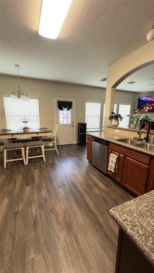 6514 Evening Rose Ln, Katy, TX 77449 - kitchen with dishwasher, a sink, dark wood-type flooring, a textured ceiling, and arched walkways