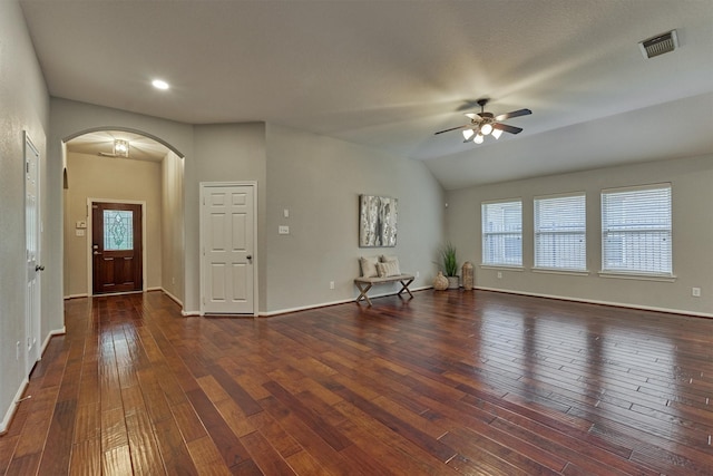 unfurnished living room featuring arched walkways, a ceiling fan, hardwood / wood-style flooring, baseboards, and vaulted ceiling