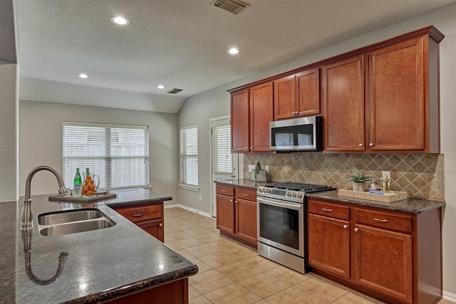 kitchen with appliances with stainless steel finishes, a sink, backsplash, light tile patterned floors, and recessed lighting