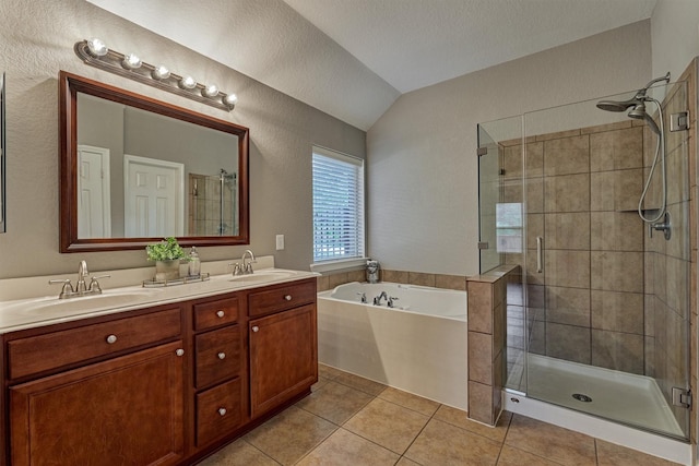 full bath featuring lofted ceiling, tile patterned floors, a shower stall, a garden tub, and double vanity