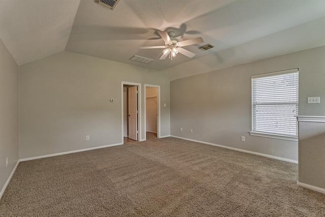 carpeted empty room with lofted ceiling, a ceiling fan, and baseboards