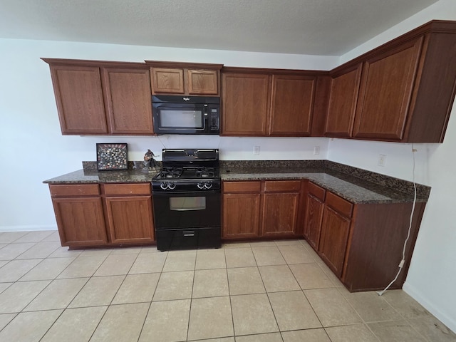 9914 Pearl Creek Ln, Rosharon, TX 77583 - kitchen featuring black appliances, dark stone countertops, light tile patterned flooring, and baseboards
