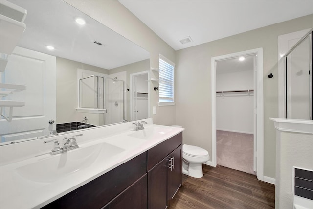 23431 Wrexham St, Spring, TX 77373 - full bathroom with a shower stall, wood finished floors, double vanity, a spacious closet, and toilet
