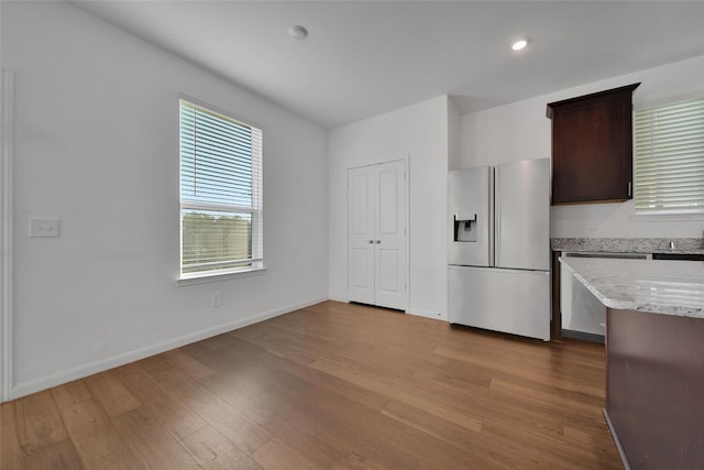 23431 Wrexham St, Spring, TX 77373 - kitchen with stainless steel appliances, wood finished floors, baseboards, dark brown cabinetry, and light stone counters