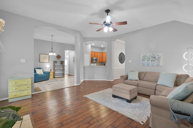 living room featuring hardwood / wood-style flooring, arched walkways, and ceiling fan
