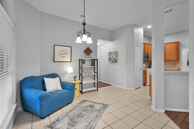 sitting room featuring a chandelier, baseboards, light tile patterned floors, and recessed lighting