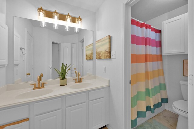 bathroom featuring toilet, tile patterned flooring, double vanity, and a shower with curtain