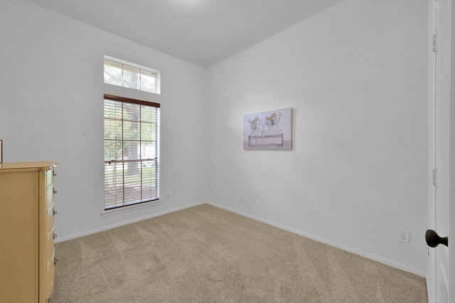 empty room with light colored carpet and baseboards