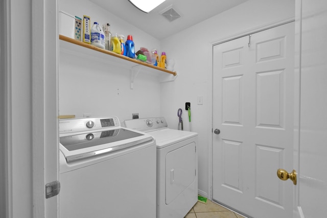 clothes washing area featuring separate washer and dryer and light tile patterned floors