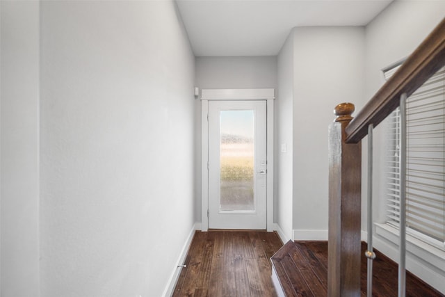 doorway with dark wood-type flooring and baseboards