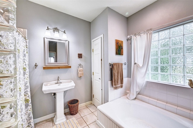 full bathroom featuring a bath, baseboards, and tile patterned floors